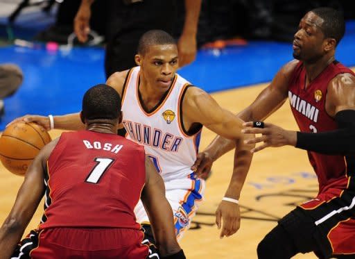 Oklahoma City Thunder's Russell Westbrook (C) drives the ball past Miami Heat's Chris Bosh (L) and Dwyane Wade during game one of the NBA Finals on June 12. Oklahoma City delivered the first blow of the best-of-seven championship series with a 105-94 win