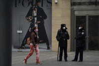 Security personnel watch over a retail street in Beijing Wednesday, March 3, 2021. The state of the world's second largest economy takes precedence among the myriad issues presented by Chinese Premier Li Keqiang in his address at the National People's Congress opening session to take place on Friday, March 5. 2021. (AP Photo/Ng Han Guan)