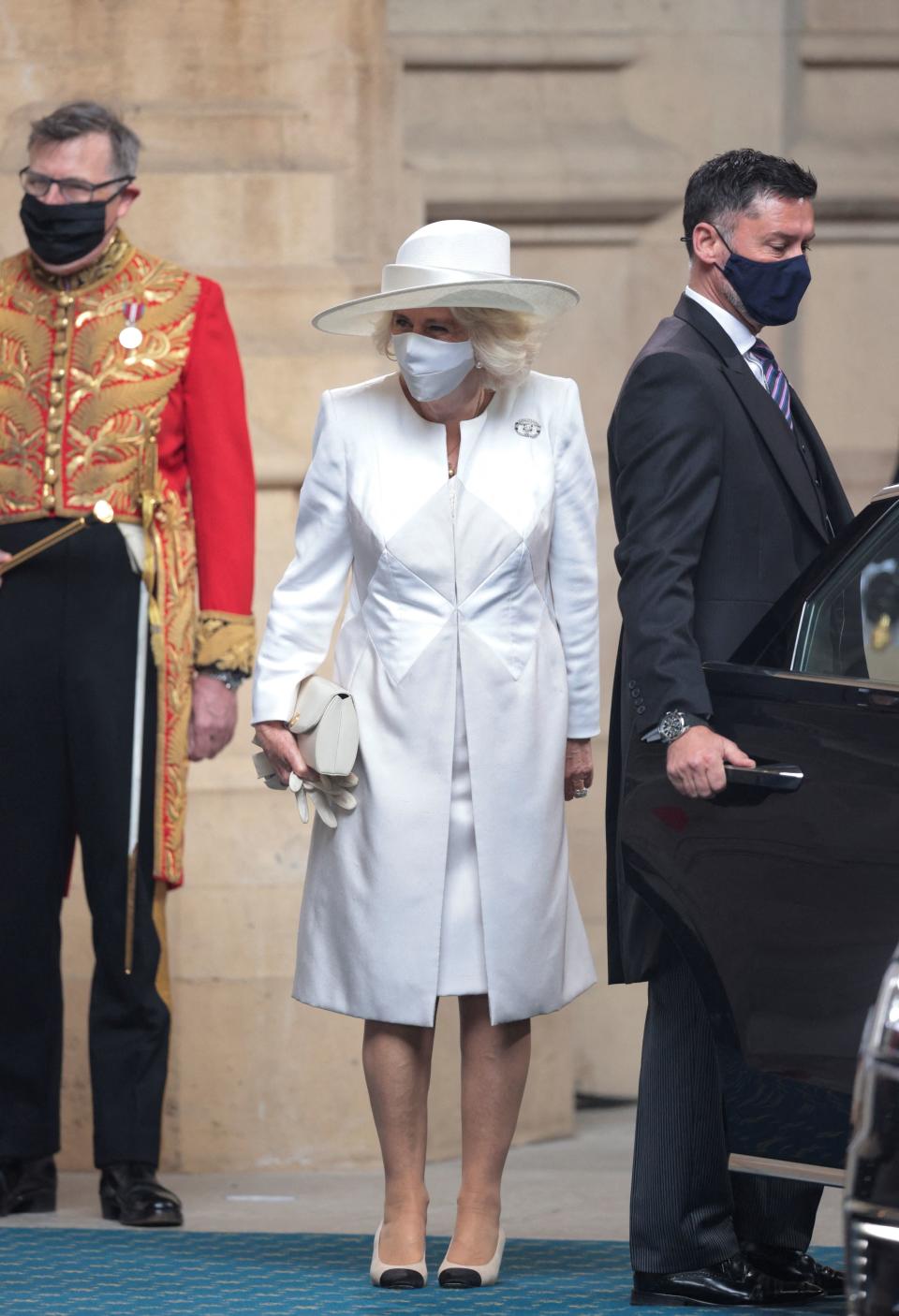 Britain's Camilla, Duchess of Cornwall (C), wearing a face covering,  arrives for the State Opening of Parliament at the Houses of Parliament in London on May 11, 2021, which is taking place with a reduced capacity due to Covid-19 restrictions. - The State Opening of Parliament is where Queen Elizabeth II performs her ceremonial duty of informing parliament about the government's agenda for the coming year in a Queen's Speech. (Photo by HANNAH MCKAY / POOL / AFP) (Photo by HANNAH MCKAY/POOL/AFP via Getty Images)