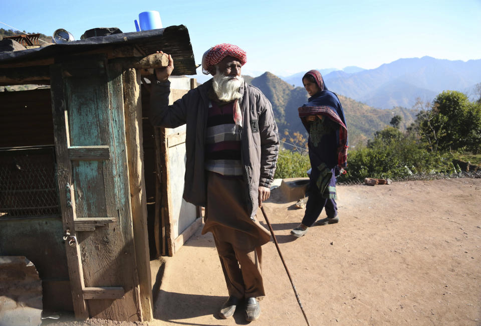 An elderly Indian Noordin, who alleges his son Altaf Hussain was killed by Pakistan army while ferrying ration supplies to one of the Indian army border posts, stands outside his house in Poonch, India, Wednesday, Dec. 16, 2020. The terrain is tough and the life of civilians living in the area is even tougher, with them often caught in the line of fire along the Line of Control, that for the past 73 years divided the region between the two nuclear-armed rivals of India and Pakistan. Over the last year, troops from the two sides have traded fire almost daily along the frontier, leaving dozens of civilians and soldiers dead. (AP Photo/Channi Anand)