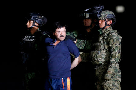 FILE PHOTO: Soldiers escort drug lord Joaquin "El Chapo" Guzman during a presentation to the media in Mexico City, Mexico January 8, 2016. REUTERS/Tomas Bravo/File Photo