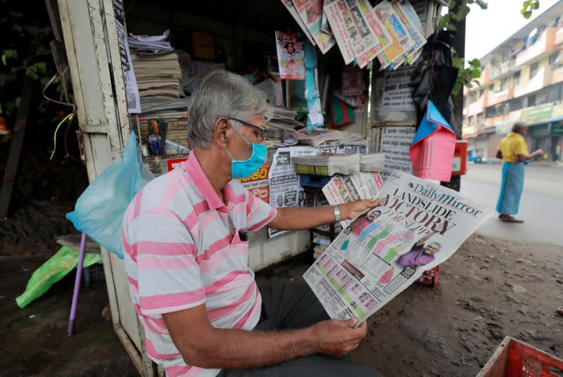 A man reads a newspaper carrying a headline of the victory of Sri Lanka People's Front party leader Rajapaksa at the country's parliamentary election in Colombo