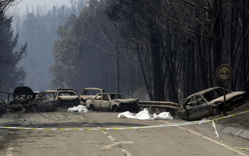 Burned out cars and blankets draped over victims