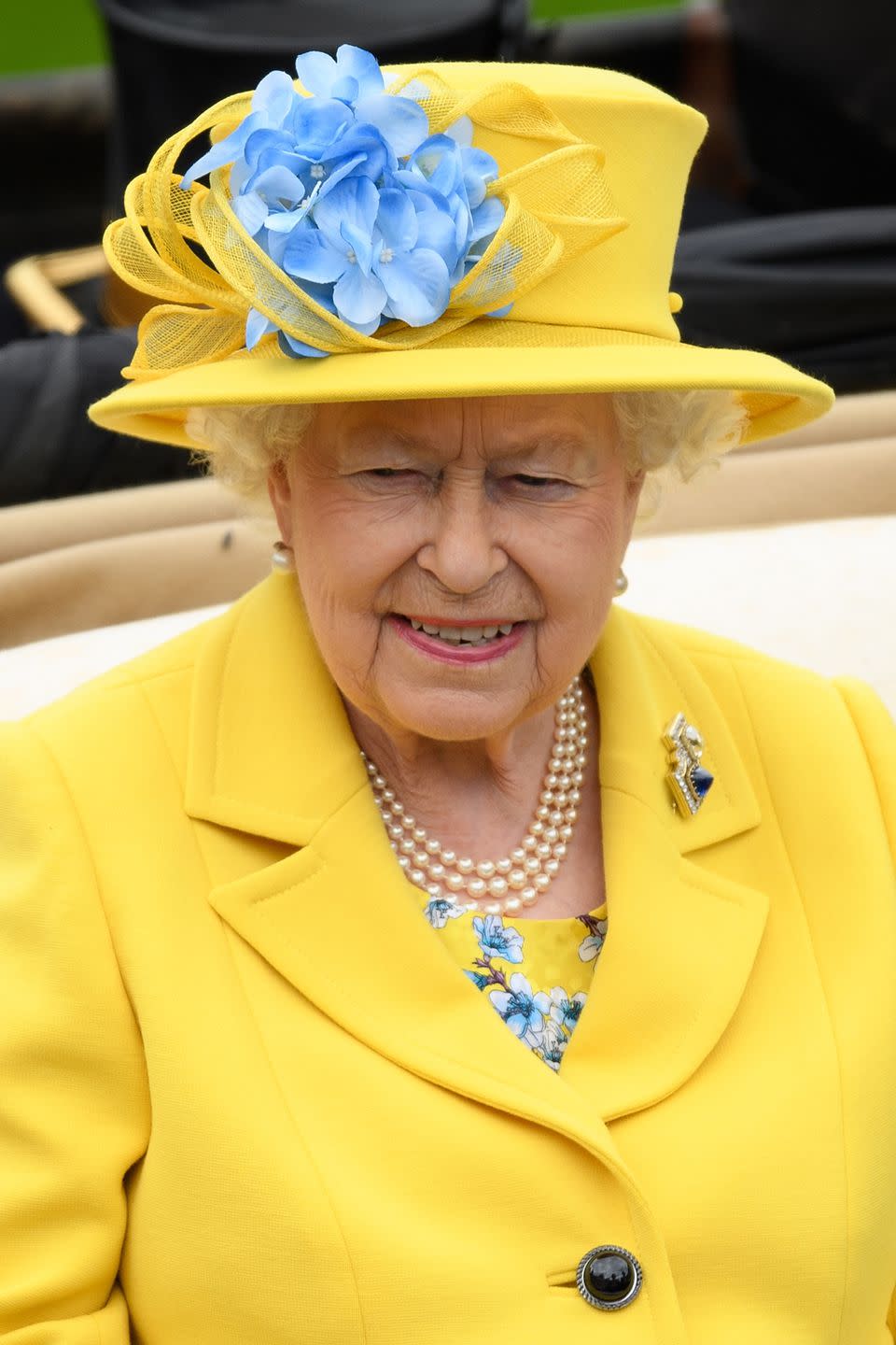 <p>Queen Elizabeth II was sunny in a yellow topper, with accents of blue flowers. </p>