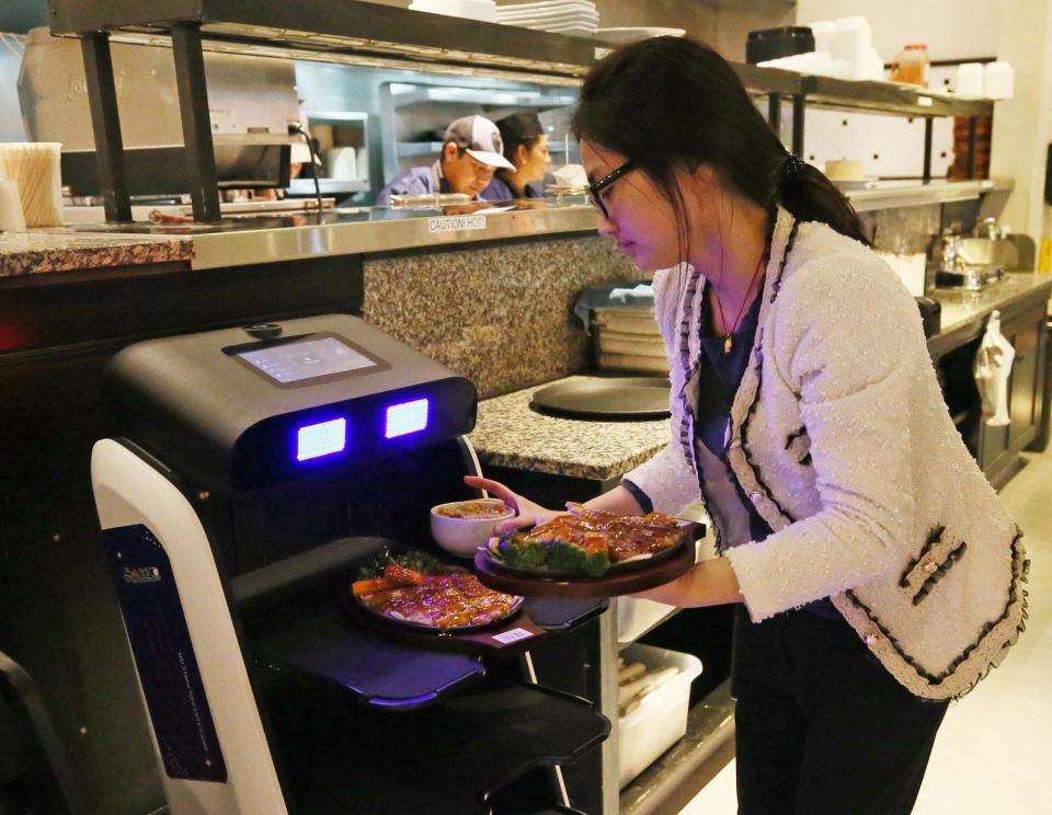 Co-owner Tiffany Chen places an order on a server robot at the new restaurant Sake Japanese Fusion.