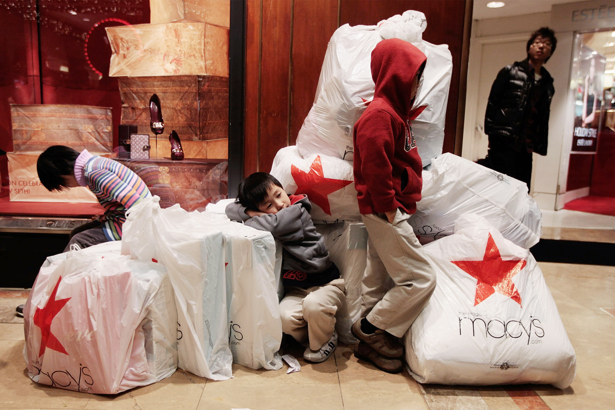 Children wait with shopping bags inside Macy's department store on "Black Friday" shopping day November 26, 2010 in New York City.
