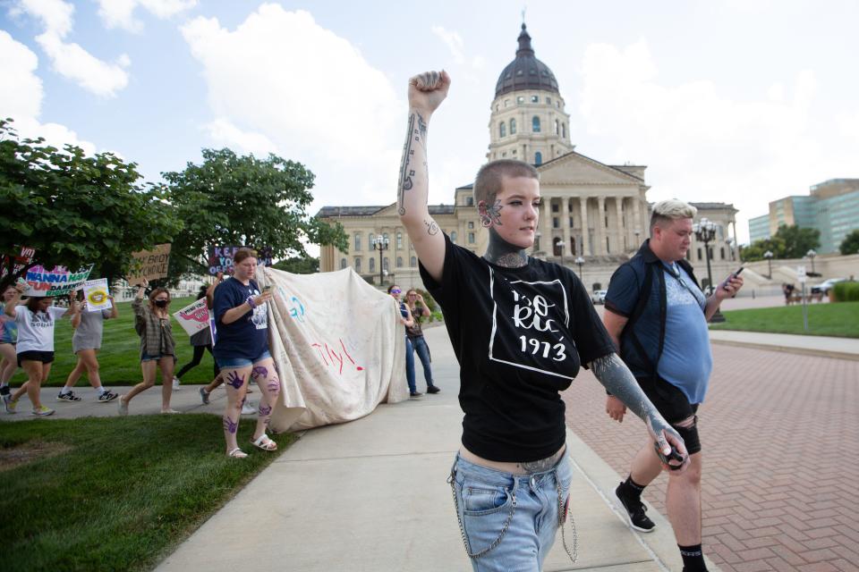 Lin Marando, middle, leads a march around the Kansas Statehouse alongside Jae Moyer, right, following an abortion-rights rally Saturday. Marando and Moyer spoke at the rally sharing stories of how abortion rights affect their lives and the lives of others.