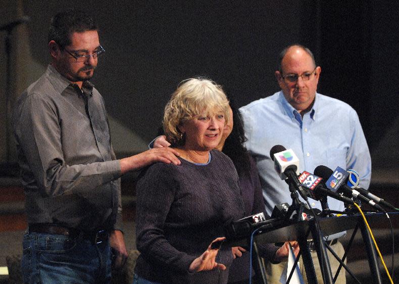 Krystle Dikes' father Shaun Dikes, left, reaches out to support his wife Charlotte, center, as the family addresses the media during a press conference at the First Baptist Church in Bristol, Ind. Saturday, Jan. 18, 2014. Dikes' mother Juanita Whitacre and her husband, David are standing with the Dikes. Shawn Walter Bair of Elkhart shot and killed Krystle Dikes Wednesday night at a Martin's Super Market in Elkhart. He also killed 44-year-old shopper Rachelle Godfread before being fatally shot by police. (AP Photo/The Elkhart Truth, Jennifer Shephard)