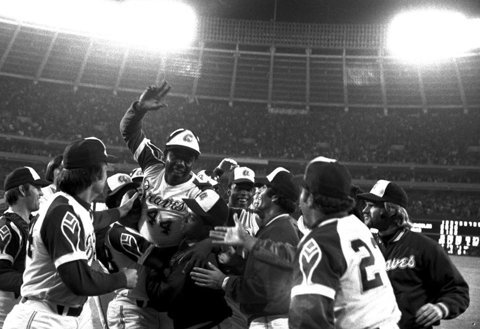 FILE - Atlanta Braves' Hank Aaron, top, is congratulated by teammates at home plate after hitting his 715th career home run in a game against the Los Angeles Dodgers in Atlanta, Monday night, April 8, 1974. Just in time for the 50-year anniversary of Hank Aaron's record 715th home run, Charlie Russo is making available video he shot of the homer. (AP Photo/Charles Knoblock, File)