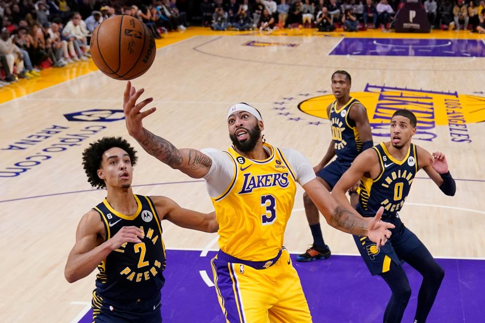 Los Angeles Lakers forward Anthony Davis, second from left, reaches for a rebound as Indiana Pacers guard Andrew Nembhard, left, guard Bennedict Mathurin, second from right, and guard Tyrese Haliburton watch during the second half of an NBA basketball game Monday, Nov. 28, 2022, in Los Angeles. (AP Photo/Mark J. Terrill)