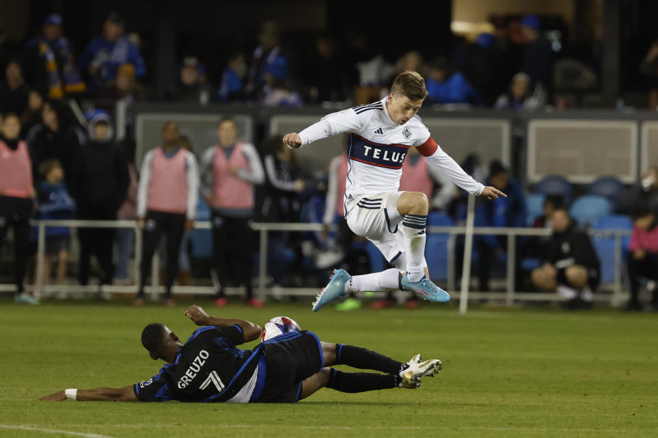 San Jose Earthquakes midfielder Carlos Gruezo (7) slide-tackles Vancouver Whitecaps midfielder Ryan Gauld during the second half of an MLS soccer match in San Jose, Calif., Saturday, March 4, 2023. (AP Photo/Josie Lepe)