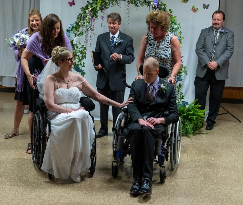 Flanked by family and well-wishers, Sara Smouther and Matt Weeks prepare to receive well-wishers, Cloverdale, Ind., Saturday, May 21, 2022, after their wedding. The couple, who have the same inherited fatal disease, live in a Cloverdale community for Huntington’s patients. 