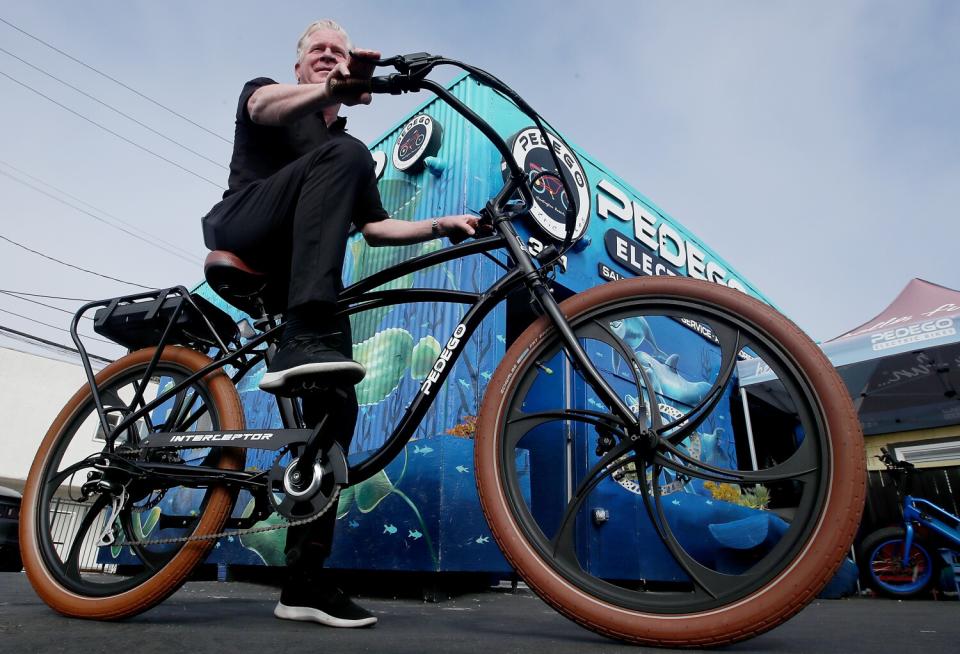 Tom Bock, owner of Pedego Electric Bikes in Huntington Beach, rides an e-bike.