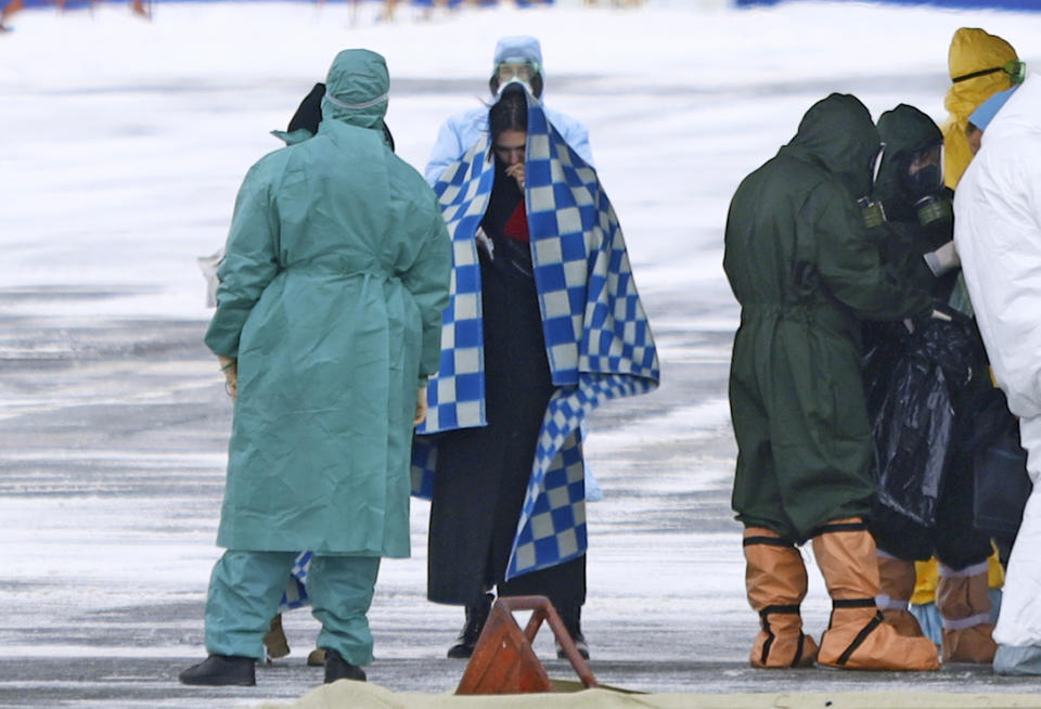 A group of medical personnel meet people, carried by a Russian military plane at an airport outside Tyumen, Russia, Wednesday, Feb. 5, 2020. Russia has evacuated 144 people, Russians and nationals of Belarus, Ukraine and Armenia, from the epicenter of the coronavirus outbreak in Wuhan, China, on Wednesday. All evacuees will be quarantined for two weeks in a sanatorium in the Tyumen region in western Siberia, government officials said. (AP Photo/Maxim Slutsky)