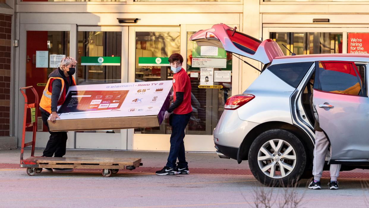 Target employees help a customer put a large screen TV into a vehicle in Rosemont, Illinois, on Nov. 26, 2021. (Photo by Joel Lerner/Xinhua via Getty Images)