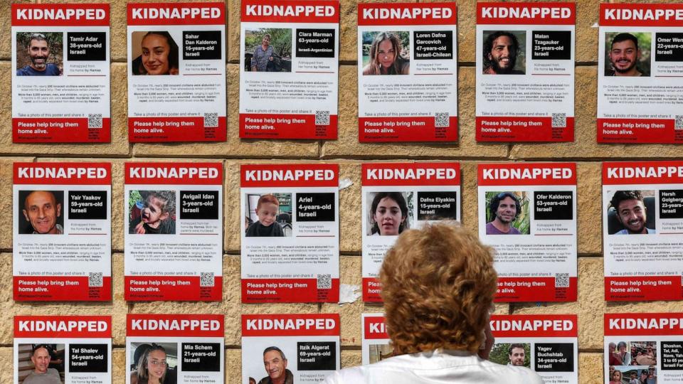 PHOTO: A woman looks at posters showing the pictures of Israeli hostages held by Palestinian militants since the Oct. 7 attack, near Azrieli Mall in Tel Aviv on Oct. 18, 2023. (Ahmad Gharabli/AFP via Getty Images)
