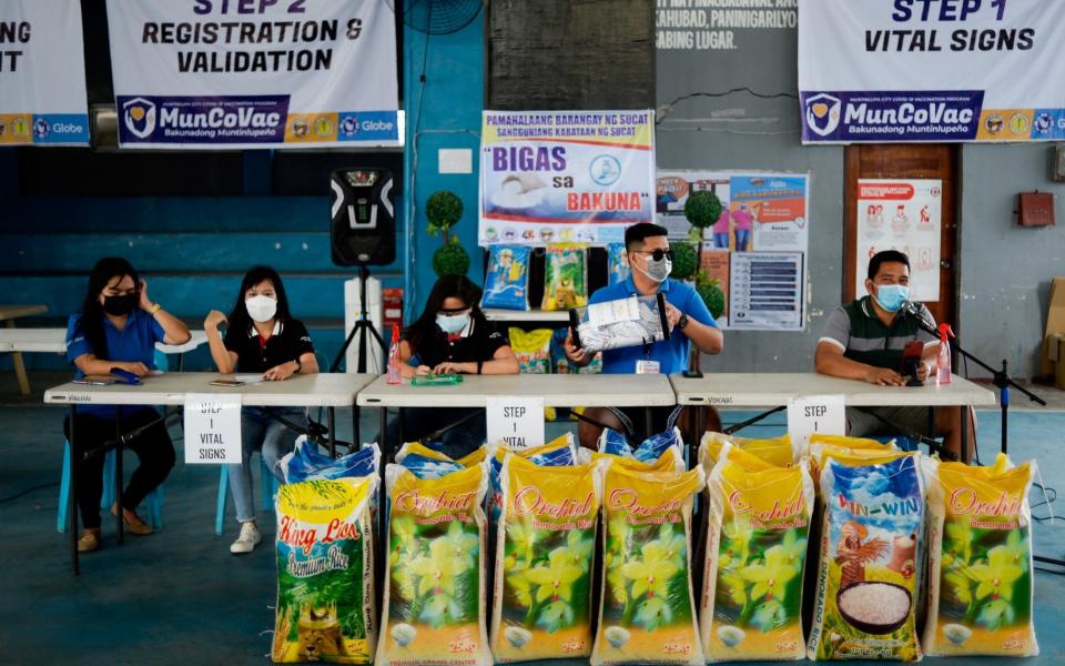 Village officials hold the weekly raffle draw of sacks of rice for residents vaccinated against the coronavirus disease (COVID-19), at the Barangay Sucat Covered Court, in Muntinlupa City, Metro Manila, Philippines, June 20, 2021. Picture taken June 20, 202 - Reuters