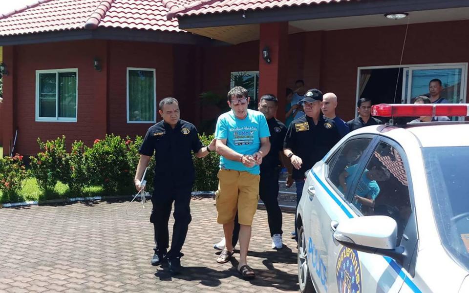 Francesco Galdelli (C) after he was arrested on the outskirts of Pattaya. An Italian who masqueraded as Hollywood superstar George Clooney to sell clothes online.  - AFP