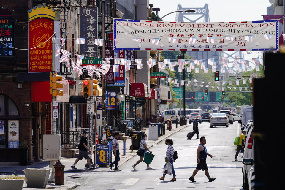 Pedestrians walk in the Chinatown neighborhood of Philadelphia, Friday, July 22, 2022. Organizers and members of Philadelphia's Chinatown say they were surprised by the 76ers' announcement that they hope to build a $1.3 billion arena just a block from the community’s gateway arch. (AP Photo/Matt Rourke)