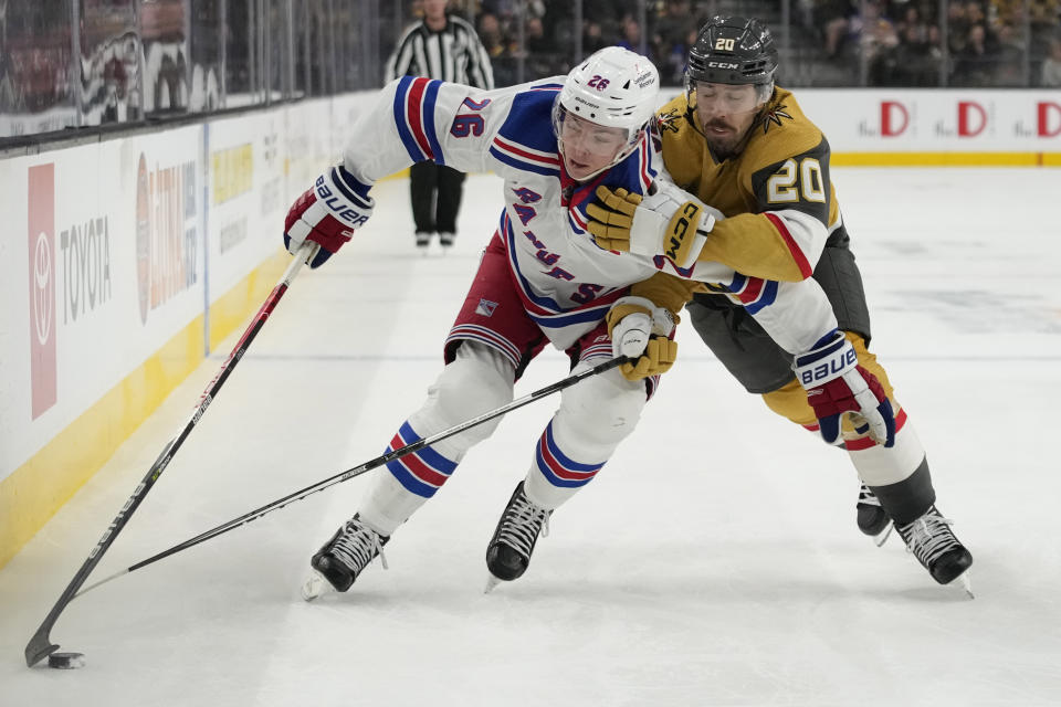 New York Rangers left wing Jimmy Vesey (26) skates around Vegas Golden Knights center Chandler Stephenson (20) during the first period of an NHL hockey game Wednesday, Dec. 7, 2022, in Las Vegas. (AP Photo/John Locher)