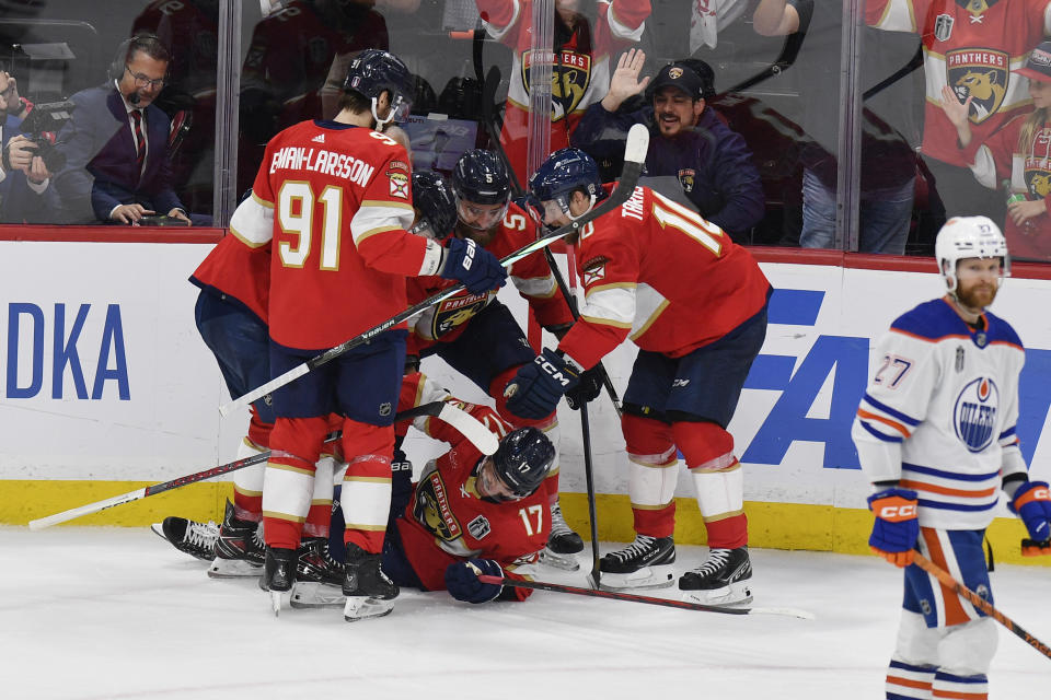 Florida Panthers center Evan Rodrigues (17) is congratulated by teammates after scoring during the third period of Game 2 of the NHL hockey Stanley Cup Finals against the Edmonton Oilers, Monday, June 10, 2024, in Sunrise, Fla. (AP Photo/Michael Laughlin)
