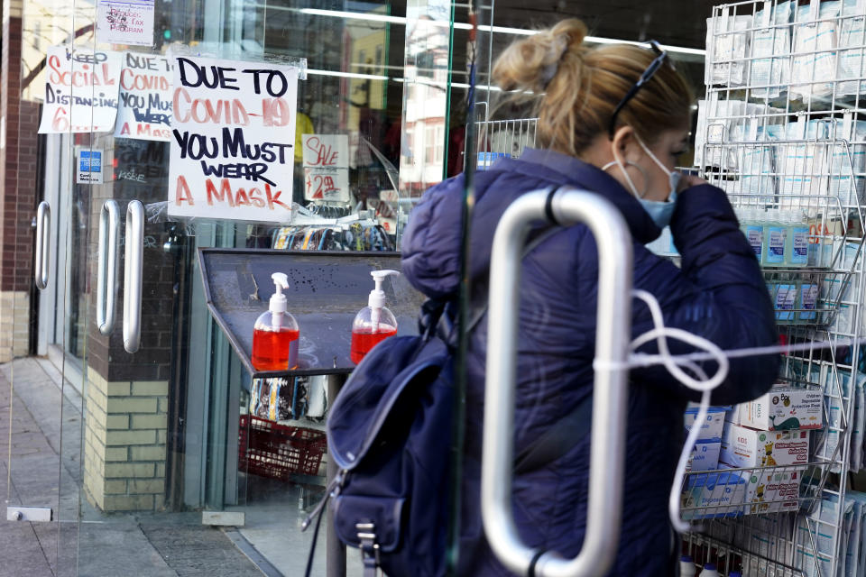 FILE - In this Nov. 24, 2020, file photo, a sign warns patrons to wear a mask in the Ironbound section of Newark, N.J. After a punishing fall that left hospital struggling, some Midwestern states are seeing a decline in new coronavirus cases. But the signs of improvement are offset by the infection’s accelerating spread on both coasts. (AP Photo/Seth Wenig, File)