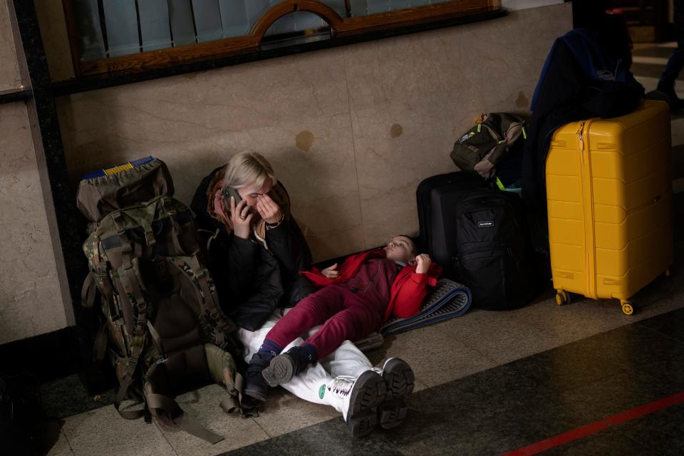 A woman with her daughter waits for a train as they try to leave Kyiv, Ukraine, Thursday, Feb. 24, 2022. Russian troops have launched their anticipated attack on Ukraine.