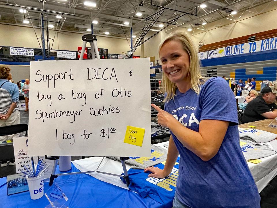 DECA adviser Cynthia Rhoden offers up bags of cookies while DECA club students comb the fair looking for cookie customers at the 70th annual Karns Community Fair at Karns High School on July 15, 2023.