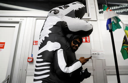 A man dressed like a dinosaur is seen prior to the 'Colossal Fossil' award, offered by environmental activists from the The Climate Action Network (CAN), which is given to the country deemed to have done its best to block progress in the negotiations or in the implementation of the Paris Agreement, during the COP24 UN Climate Change Conference 2018 in Katowice, Poland December 13, 2018. REUTERS/Kacper Pempel