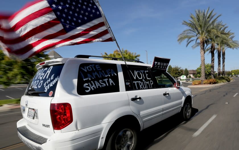 REDDING, CA - OCT. 24, 2020. A supporter of President Donald J. Trump drives through Redding on Saturday, Oct. 24, 2020. Redding is a conservative stronghold and home to the Bethel Church and its affiliated School of Supernatural Ministry. Members of the church and school have fueled a major coronavirus outbreak in Redding, with nearly 300 cases reported, Critics blame the church for Shasta County falling back to a more restrictive state tier. One church leader said masks don't work against spreading the virus. Bethel weilds infuence in the city, where members make up 10% of the population. (Luis Sinco / Los Angeles Times)
