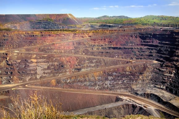 Open-pit mine with switchbacked road leading down into the active mining area.