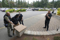 Ken Westphal, right, an officer with the Lacey Police Dept. and an instructor at the Washington state Criminal Justice Training Commission, works with cadets Kevin Burton-Crow, left, of the Thurston Co. Sheriff's Dept., and LeAnne Cone, third from left, of the Vancouver Police Dept., as they search an actor playing a person who has caused a disturbance at a convenience store during a training exercise Wednesday, July 14, 2021, in Burien, Wash. Washington state is embarking on a massive experiment in police reform and accountability following the racial justice protests that erupted after George Floyd's murder last year, with nearly a dozen new laws that took effect Sunday, July 25 but law enforcement officials remain uncertain about what they require in how officers might respond — or not respond — to certain situations, including active crime scenes and mental health crises. (AP Photo/Ted S. Warren)