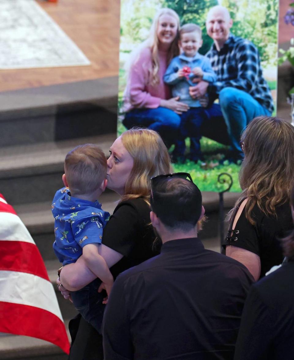 Andrew Eyer, 3 yrs., is kissed by his mother, Ashley Eyer during the funeral for his father Joshua Eyer at First Baptist Church in Charlotte, NC on Friday, May 3, 2024. Mourners gathered at First Baptist Church to honor slain Charlotte-Mecklenburg Police Officer Joshua Eyer who died from wounds sustained during a standoff with a gunman on Monday, April 29th.