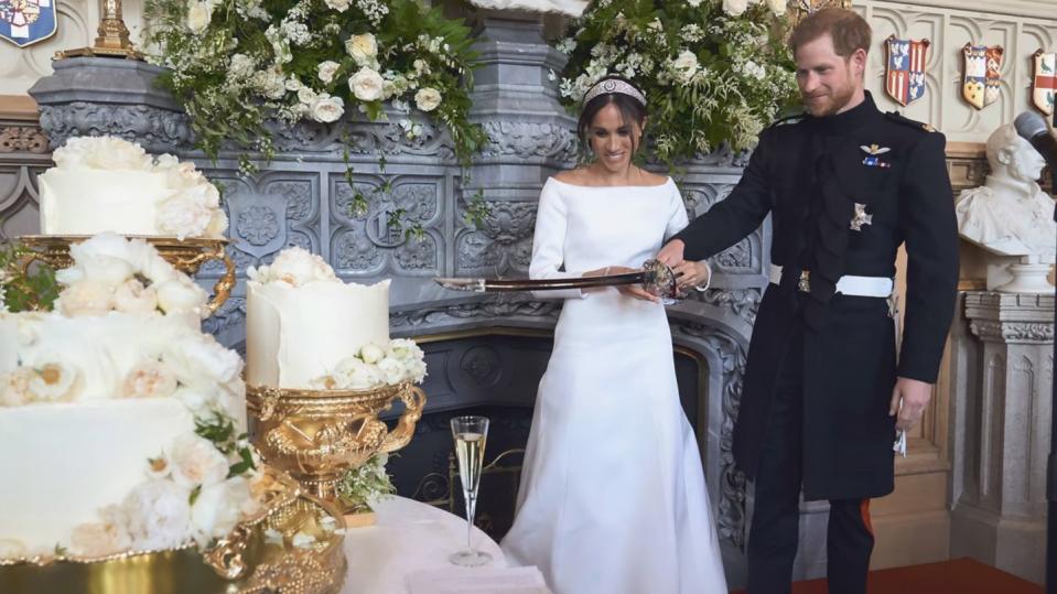 prince harry and meghan markle cutting the cake at their wedding