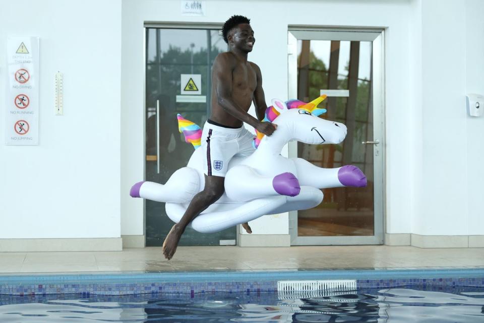 Saka shows his playful side, jumping into a swimming pool on an inflatable unicorn at St George’s Park during Euro 2020 (The FA via Getty Images)