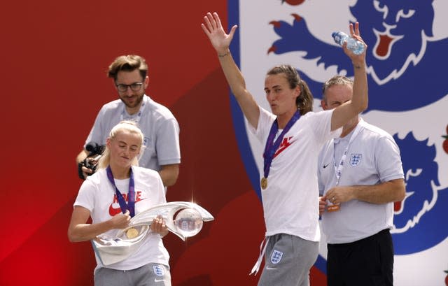 Chloe Kelly, left, plays air guitar on the Euro 2022 trophy