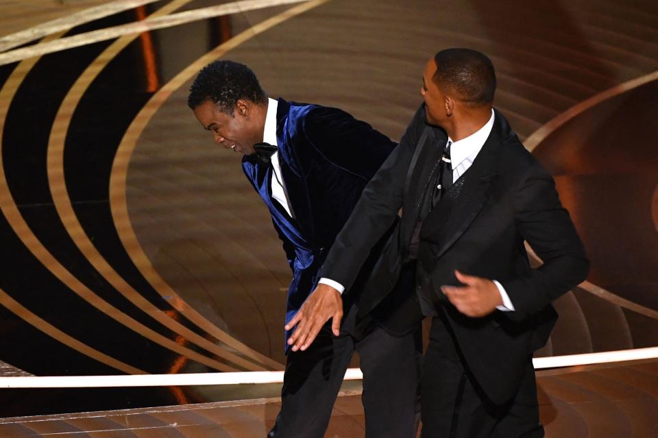 TOPSHOT - US actor Will Smith (R) slaps US actor Chris Rock onstage during the 94th Oscars at the Dolby Theatre in Hollywood, California on March 27, 2022. (Photo by Robyn Beck / AFP) (Photo by ROBYN BECK/AFP via Getty Images) ORG XMIT: 0 ORIG FILE ID: AFP_32743DJ.jpg