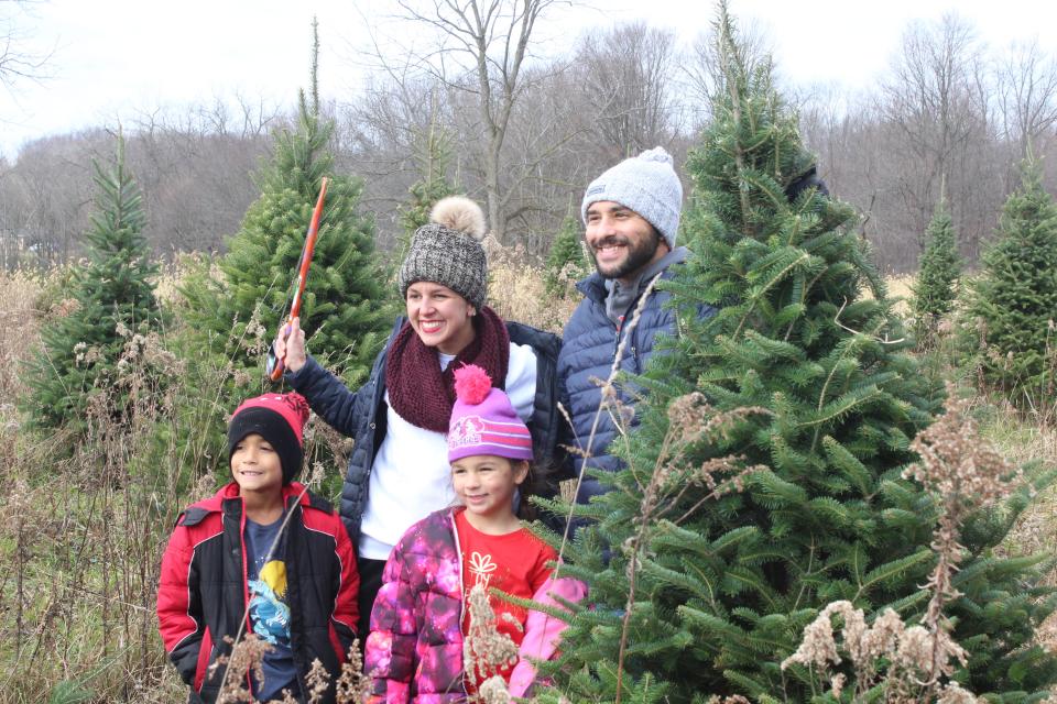 Parents Jason and Amand Jamil pose for a photo with their children Jason (front left) and Amariyae Jamil after cutting down their 2022 Christmas tree at Galehouse Tree Farm.