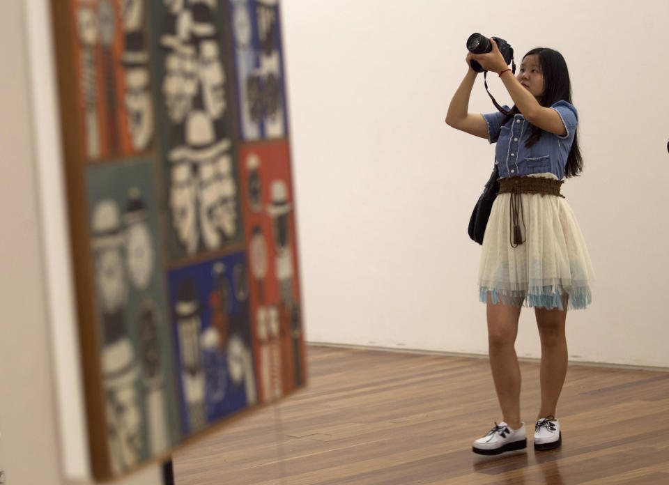 A woman takes pictures during a visit for journalists to the Rio Art Museum before its inauguration in Rio de Janeiro, Brazil, Thursday, Feb. 28, 2013. The museum, scheduled to open on Friday, is part of Rio’s multi-billion dollar bid to reinvent itself before playing host to a double header of mega-events, the 2014 World Cup soccer tournament and the 2016 Olympics. (AP Photo/Silvia Izquierdo)