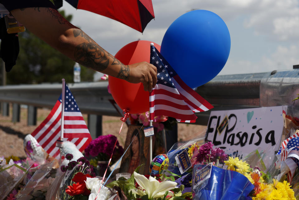 A man places an American flag in the pile of flowers that has gathered a day after a mass shooting at a Walmart store in El Paso, Texas, U.S. August 4, 2019.  REUTERS/Callaghan O'Hare     TPX IMAGES OF THE DAY