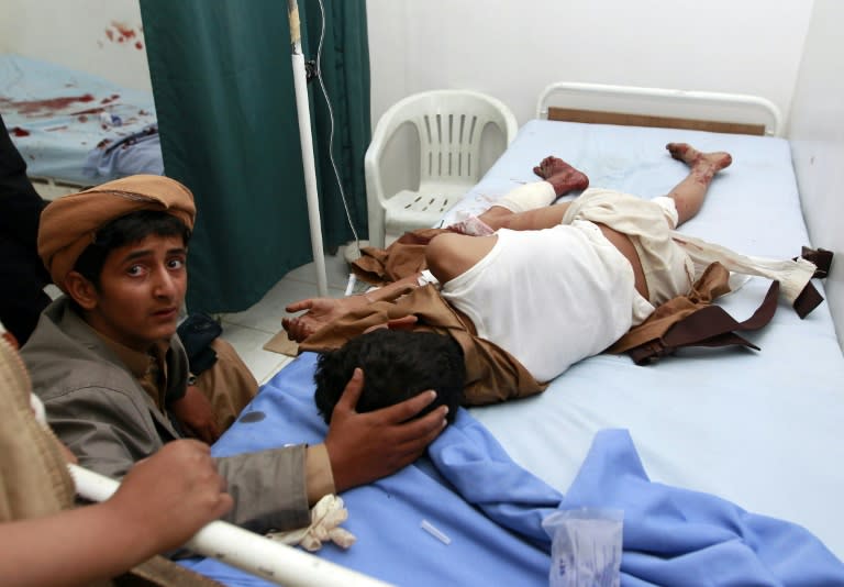 A Yemeni youth comforts an injured boy at a hospital in Sanaa after two suicide bombers hit a Shiite mosque in the Yemeni capital in quick succession on September 2, 2015 killing at least 28 people