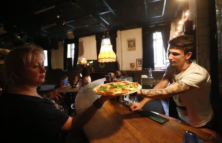 An employee serves pizza at a restaurant in Moscow, September 10, 2014. REUTERS/Maxim Zmeyev