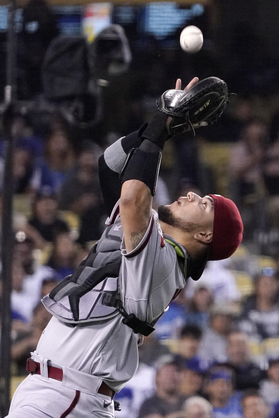 Arizona Diamondbacks catcher Jose Herrera makes a catch on a foul ball hit by Los Angeles Dodgers' Austin Barnes during the third inning of a baseball game Monday, May 16, 2022, in Los Angeles. (AP Photo/Mark J. Terrill)