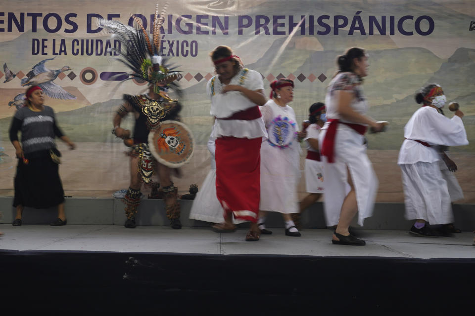 La gente realiza un baile prehispánico en la Feria de Comida Prehispánica en la delegación Iztapalapa de la Ciudad de México, el viernes 29 de julio de 2022. Iztapalapa, la delegación más grande de la Ciudad de México, lanzó la feria para rescatar y preservar la cocina tradicional mexicana. (AP Foto/Marco Ugarte)