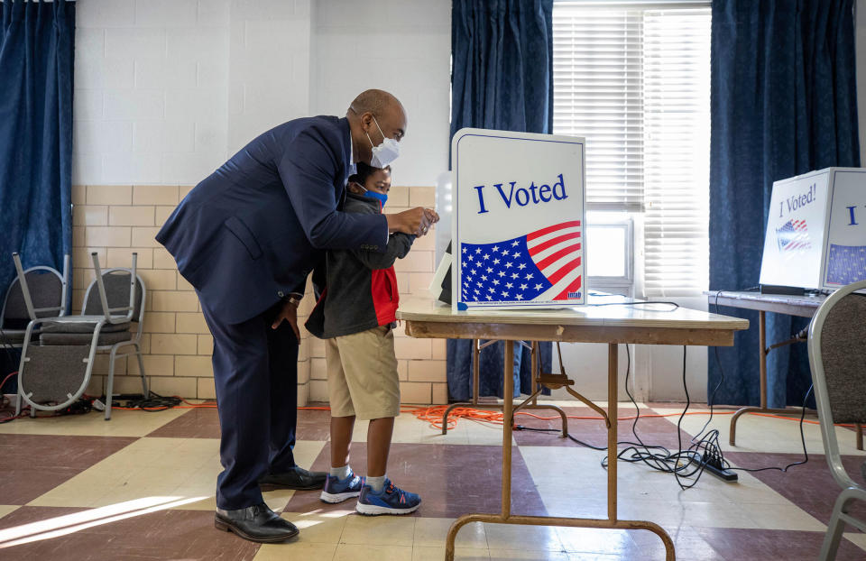 Senate candidate Jaime Harrison votes with his son, William, 6, at the Masonic Temple in Columbia, S.C. on Oct. 19, 2020.<span class="copyright">Tracy Glantz—The State/AP</span>