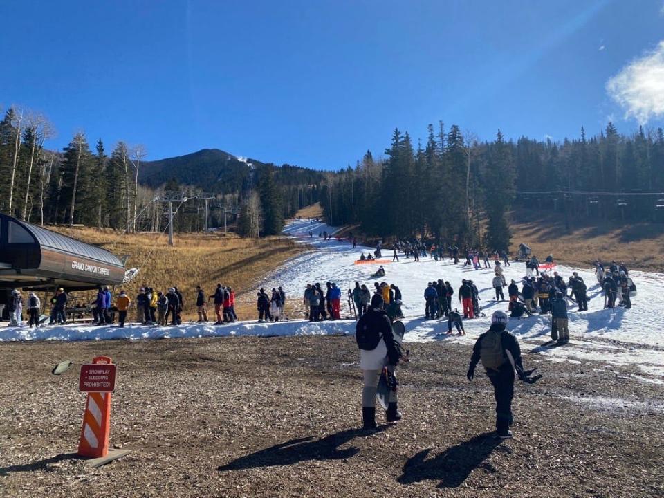 The line of skiers and snowboarders often stretched back up onto the mountain throughout the first day of the season at Arizona Snowbowl on Nov. 17, 2023.