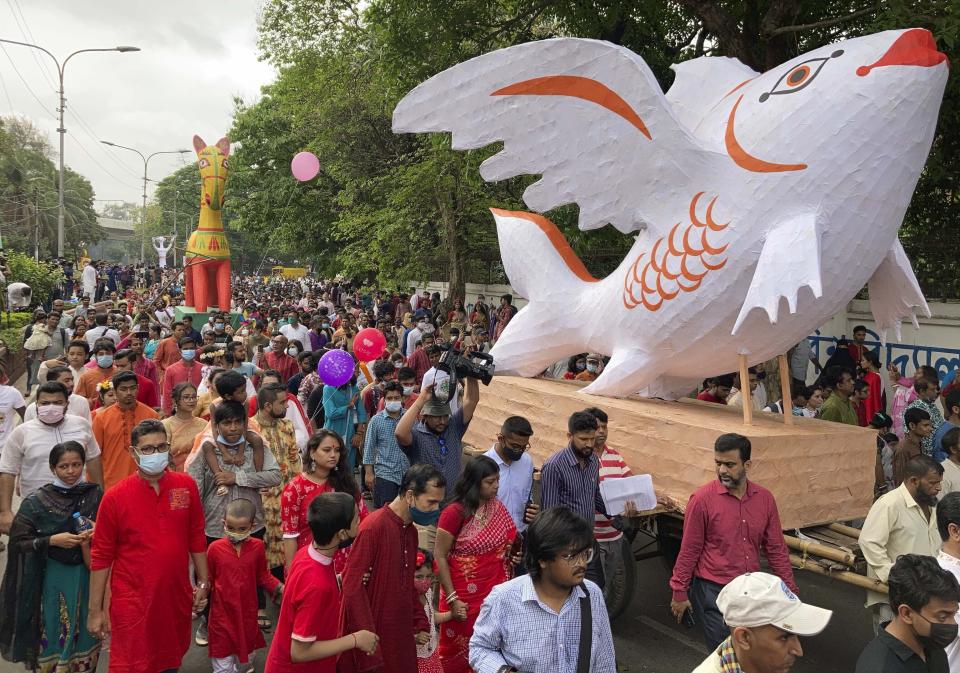 People walk in a procession to mark the Bengali New Year in Dhaka, Bangladesh, Wednesday, April 14, 2022. After a two-year break, thousands of people in Bangladesh and Nepal on Thursday celebrated their respective new years with colorful processions and musical soirees as the coronavirus pandemic eased and life swung back to normal. (AP Photo/Al Emrun Garjon)