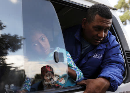 A Venezuelan migrant and his daughter are transported outside a temporary humanitarian camp that is closed by the government, in Bogota, Colombia January 15, 2019. REUTERS/Luisa Gonzalez