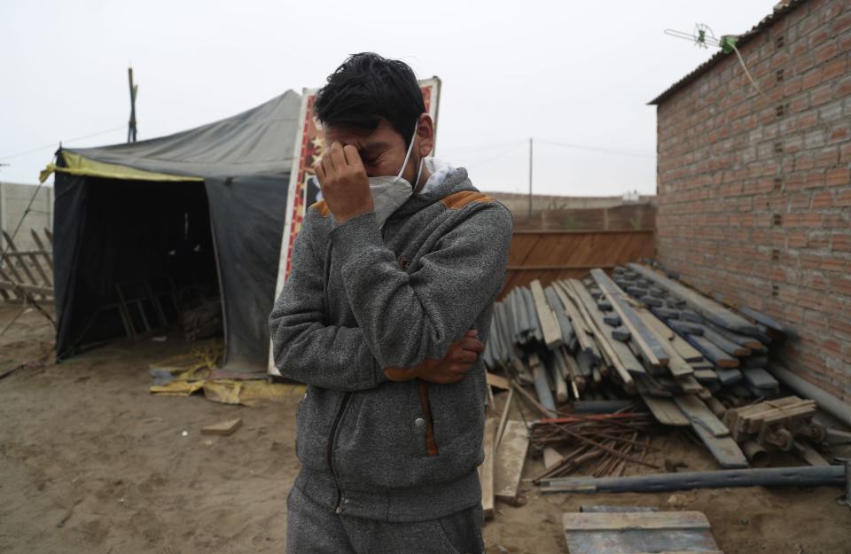 Circus clown Julio Cesar Chiroque, 38, whose clown name is "Galleta," or Cookie, tears up as he explains his family's dire economic situation brought by the economic shutdown to curb the spread of COVID-19 outside his home in a poor neighborhood on the outskirts of Lima, Peru, Monday, Aug. 10, 2020. Chiroque's family used to run their own small circus, but since March when the lockdown to curb COVID-19 closed their business, and the requirement for seniors over 60 to self-quarantine kept his father home-bound, they started selling circus food like caramelized apples to survive. (AP Photo/Martin Mejia)