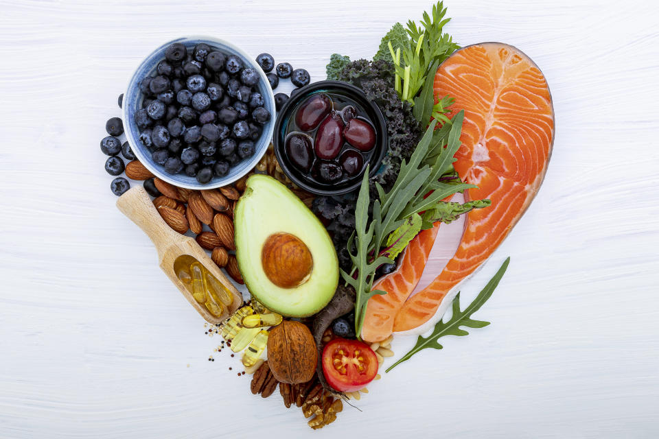 Heart shape of ketogenic low carbs diet concept. Ingredients for healthy foods selection on white wooden background. Balanced healthy ingredients of unsaturated fats for the heart and blood vessels.